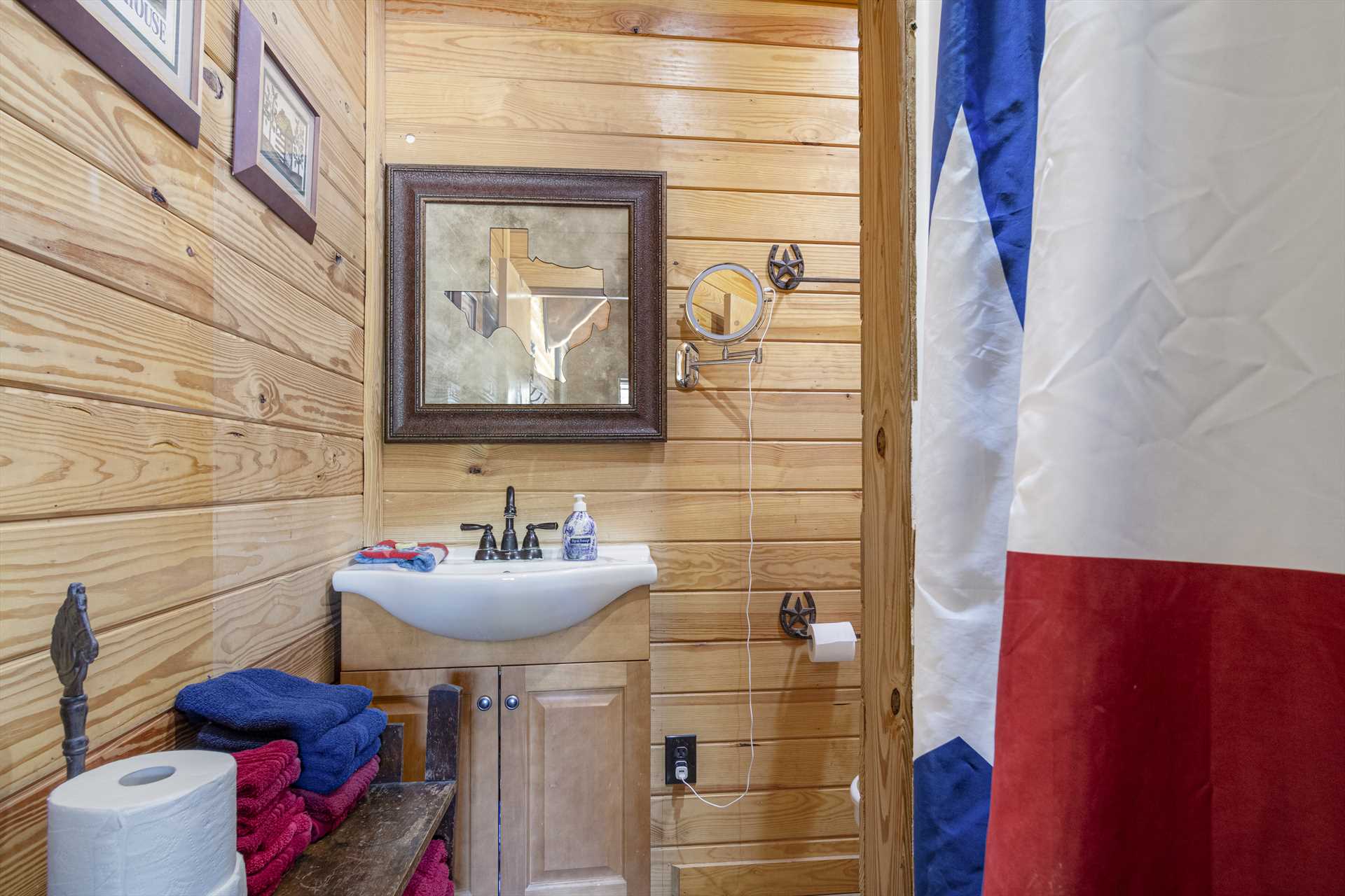                                                 The full bath at the Texan Cabin includes a step-in shower, clean linens, and a single vanity.