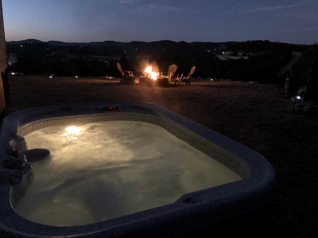                                                 The private hot tub overlooks the fire pit, and the majestic Hill Country mountains beyond.