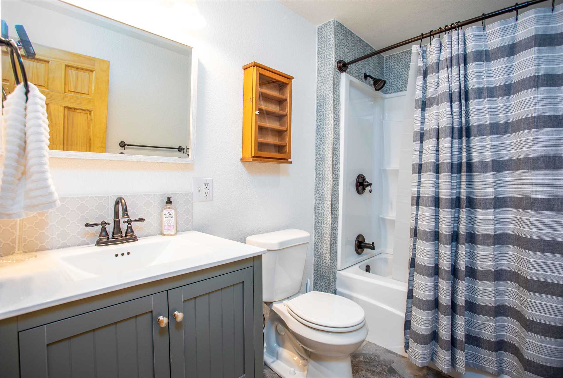                                                 The tidy master bathroom is furnished with a shower and tub combo, and fresh bath linens are provided for both baths.