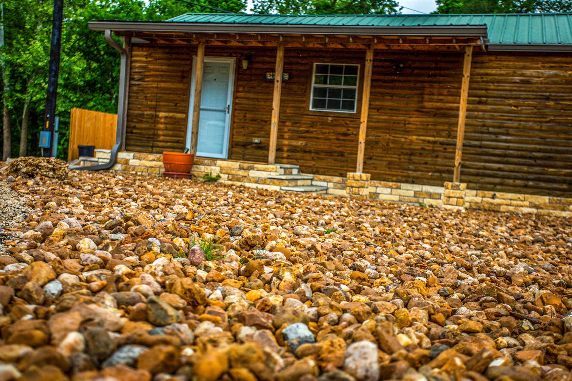                                                 Colored stones add a whimsical and elegant touch to the landscaping in front of the cabin.