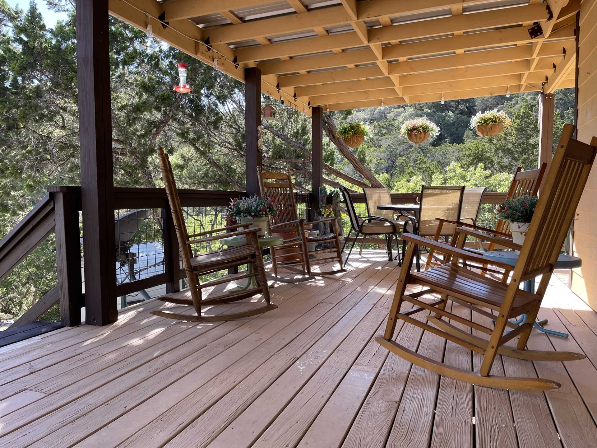                                                 Rocking chairs and an outdoor dining table on the deck make for a relaxing setting for conversation, a glass of wine, or a BBQ dinner for two.