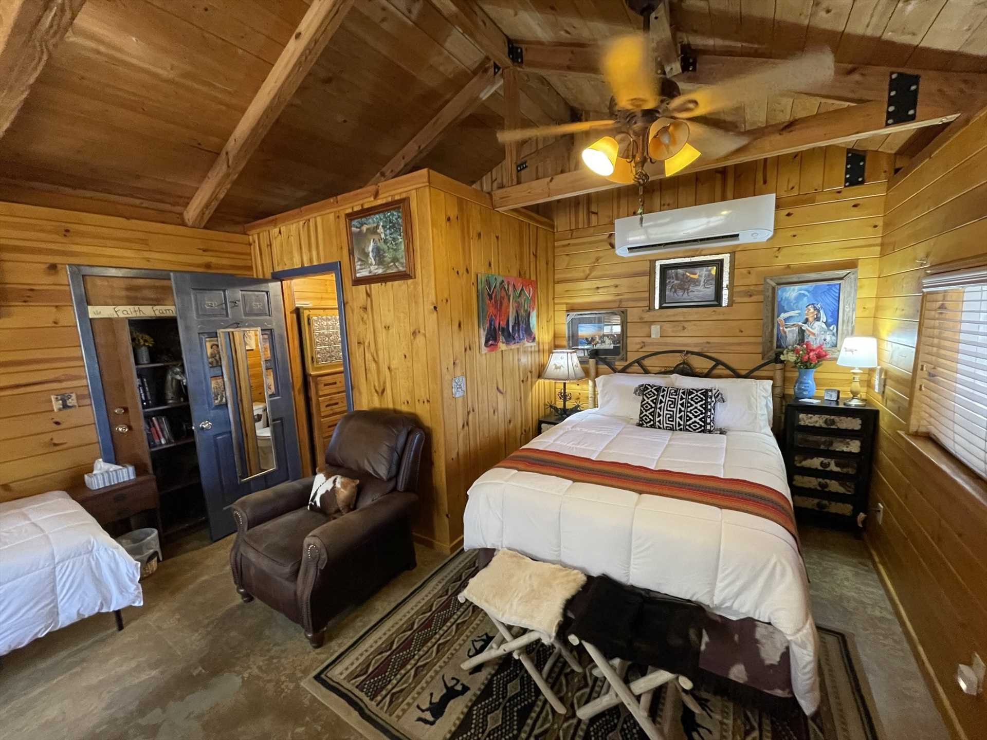                                                 A warm and welcoming queen-sized bed is tucked into its own golden-paneled nook at Giddy Up, covered in fresh linens.