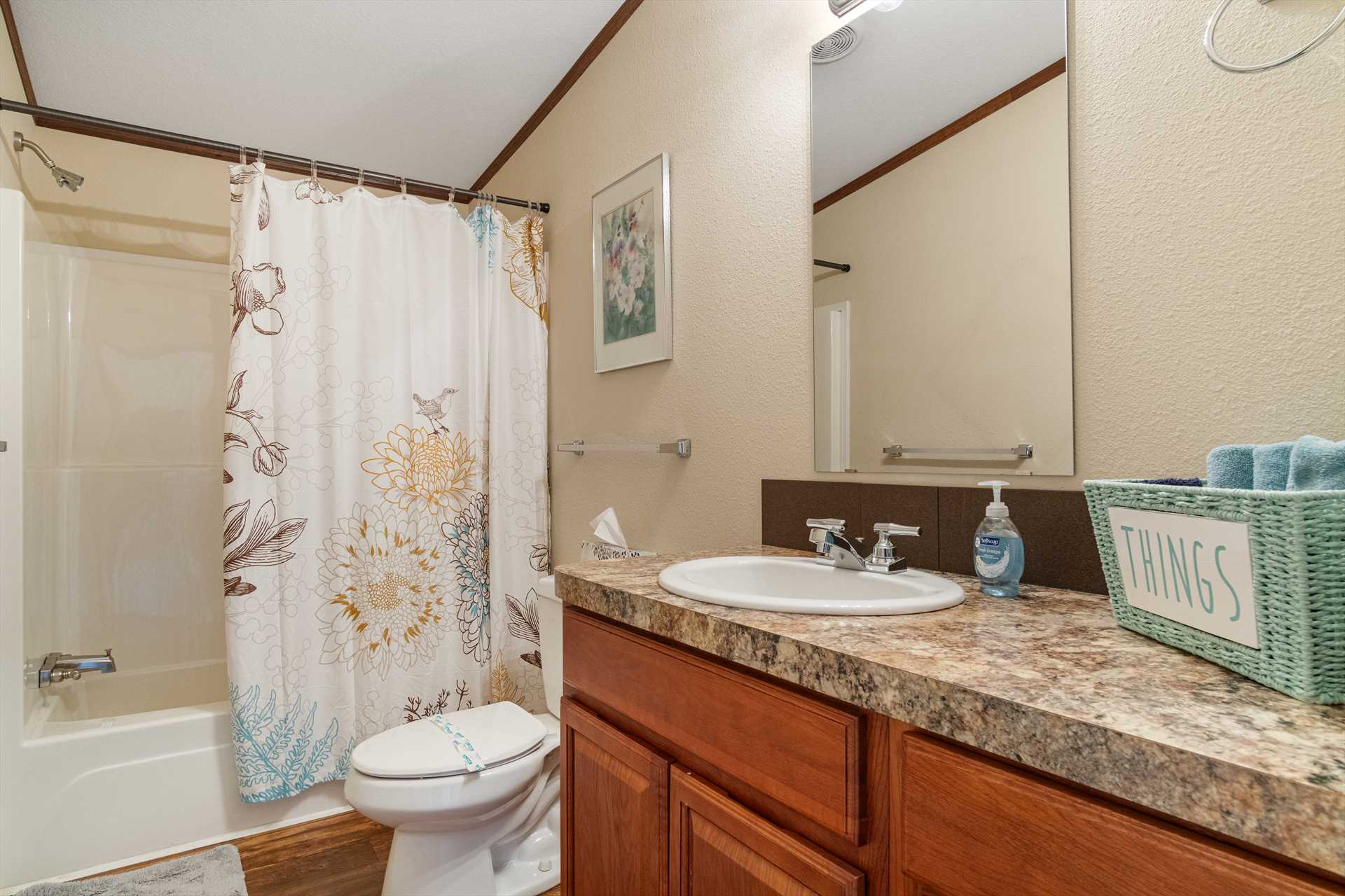                                                 A full bath with a tub and shower combo and clean, fluffy linens is shared by the second and third bedrooms.