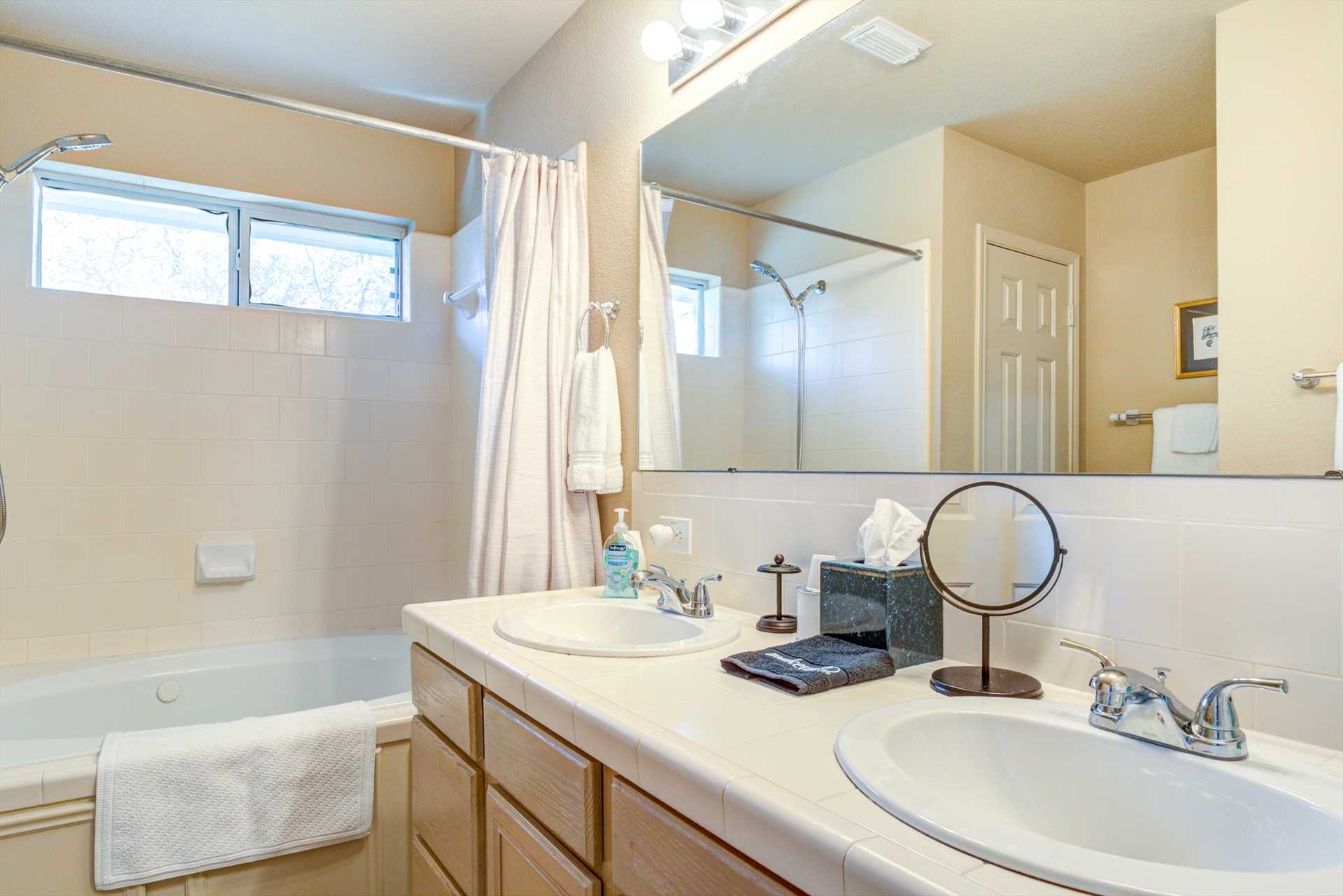                                                 Twin vanities and a big garden-style tub and shower combo await you in the master bath, complete with fresh linens!