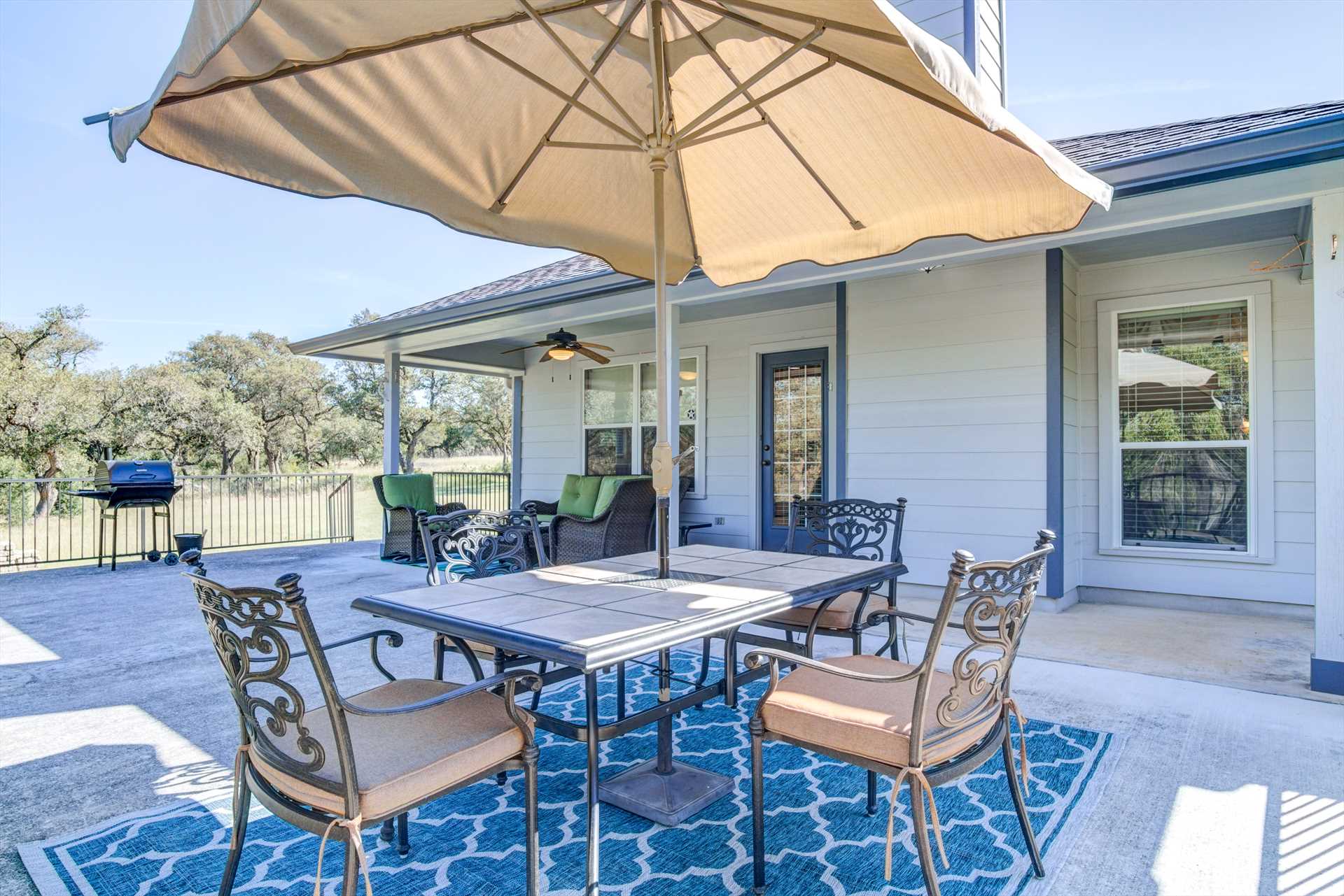                                                 The enormous outdoor patio includes a large table with an umbrella for adjustable shade, and there's also a charcoal grill for family cookouts!