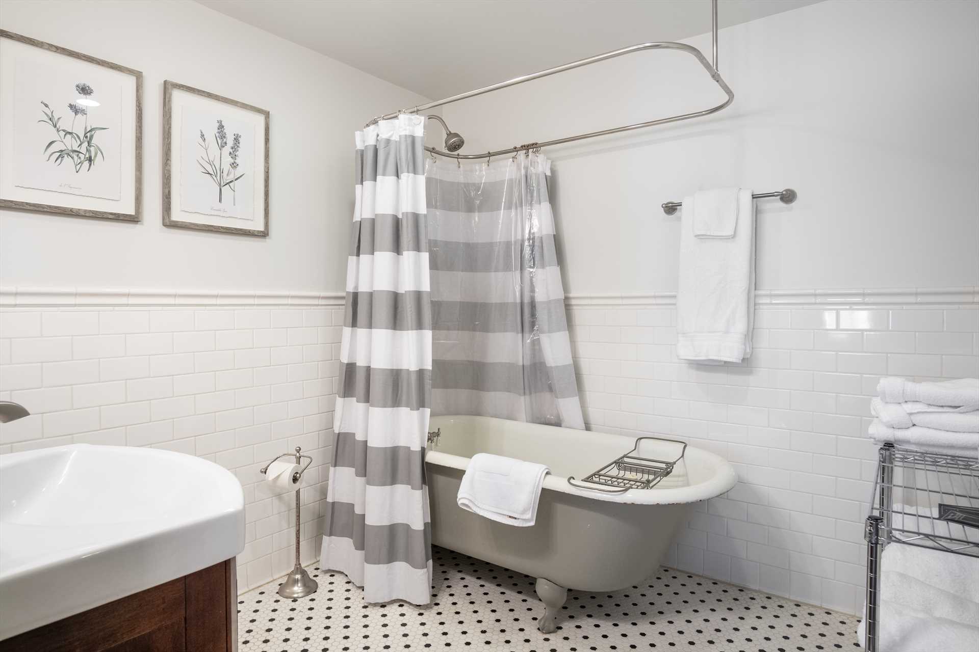                                                 A vintage clawfoot tub is the centerpiece of the shared hall bath, built into a shower-tub combo.