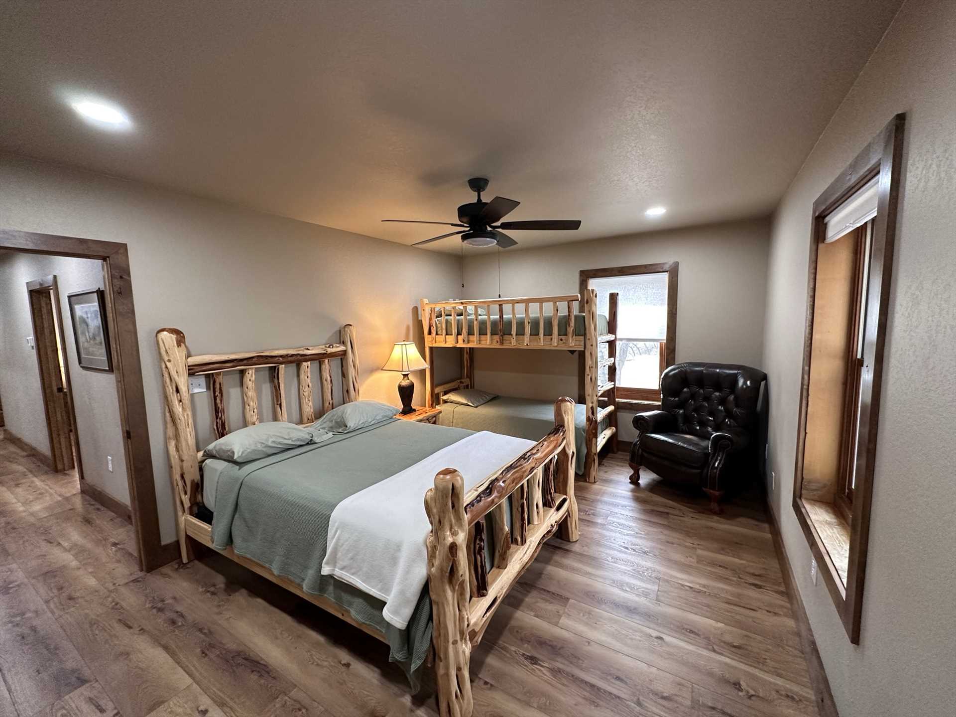                                                 The Lodge's fourth bedroom, located upstairs, comfortably sleeps four with a queen-sized bed and a twin bunk bed setup.