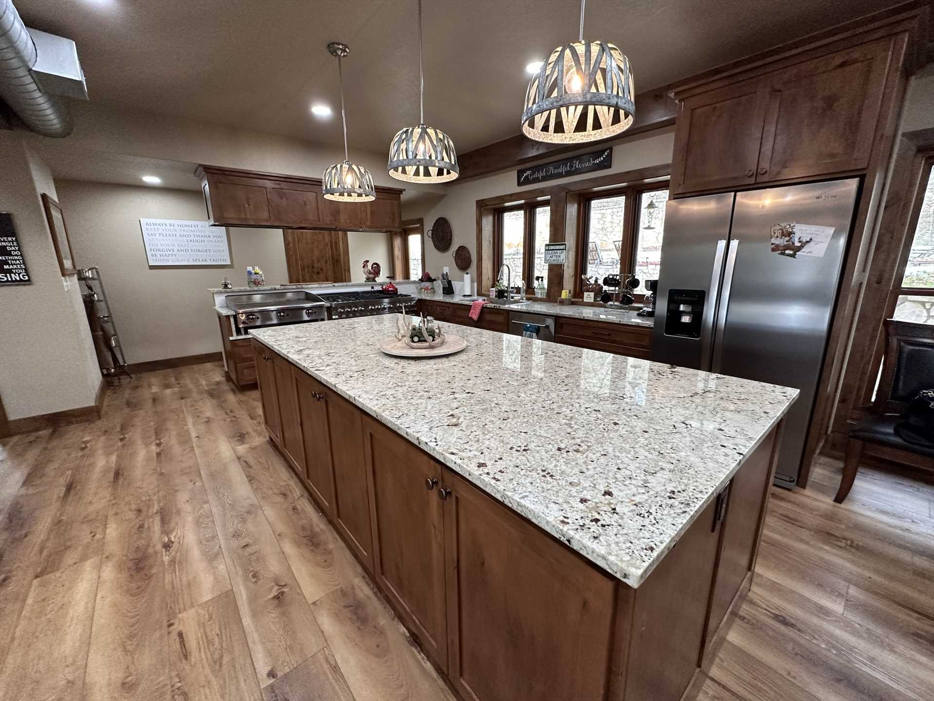                                                 A huge island creates a visual centerpiece in the kitchen, as well as tons of food prep space! There's also plenty of cooking and serving ware, glasses and utensils on hand.