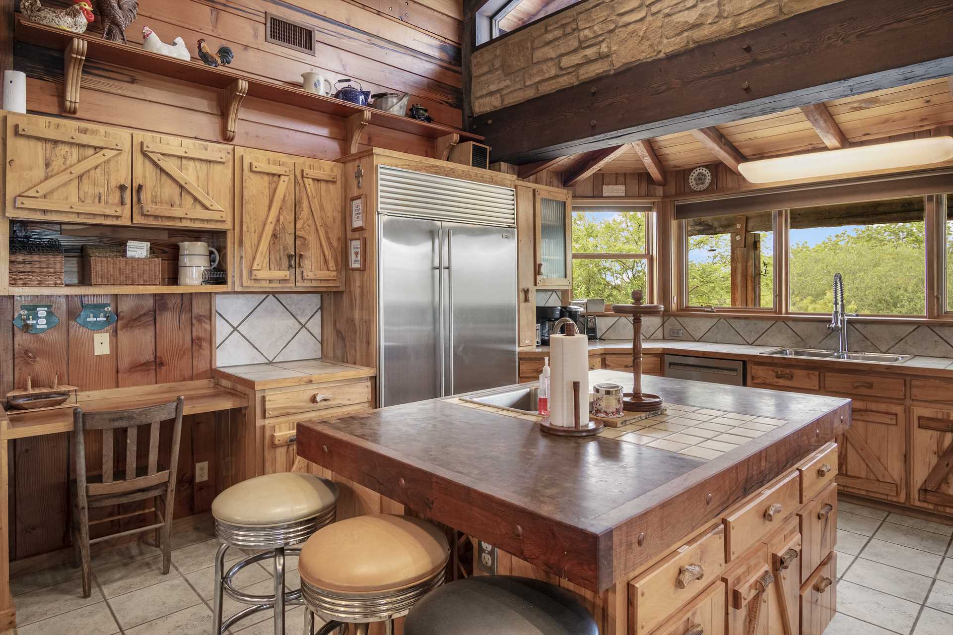                                                 Shiny appliances stand alongside the rustic woodwork, and your kitchen here includes extras like a bread warmer and ice machine!