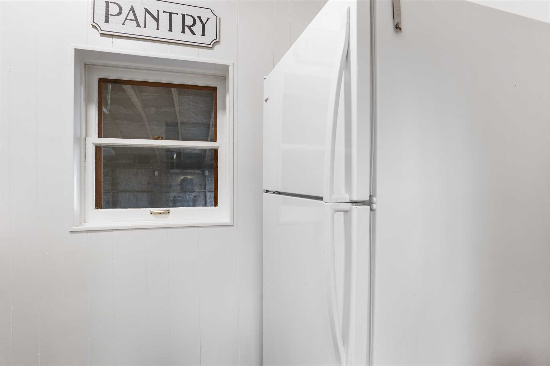                                                 A roomy fridge and freezer combo stands ready just outside the kitchen!